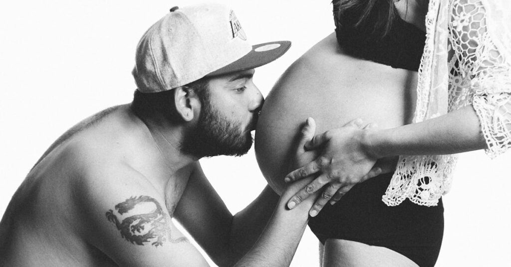 A couple sharing an intimate moment during pregnancy, highlighting love and parenthood.
